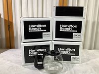 Four Hamilton Beach Commercial replacement coffee carafes presented, three in sealed boxes and one out of box for inspection.