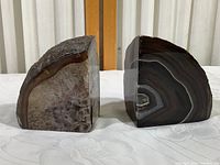 Front view of two polished agate bookends with crystal and banded faces