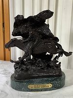Front three-quarter view of sculpture showing horse and rider in motion