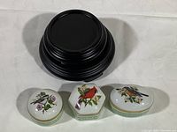 Photo of two black Asian style wooden display stands with circular shape, smooth finish, minimal design.
