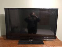 Front view of the Samsung flat screen TV on a rectangular black stand base.