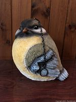 Front and side view showing realistic painted resin bird with hanging chain.