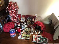 Overview of all Christmas decoration items arranged on the floor including candy canes, poinsettias, figurines, and plates.