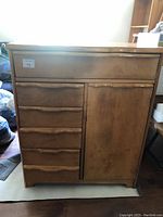 Front view of the vintage wooden dresser showing four drawers on the left and a single door on the right.