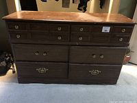 Full front view of the dresser showing six drawers and visible wear on top surface and drawer fronts.