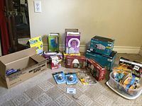 Overview of various household items including light bulbs, garbage bags, and cable ties, placed on floor against wall.