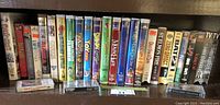 Shelf with multiple VHS movies showing front cover titles and spines.