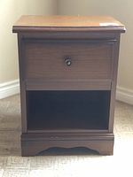 Front view of the smaller nightstand showing the single drawer and lower open shelf with a round drawer knob.