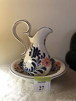 Photo of ceramic wash pitcher with curved handle and floral decoration