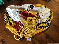 Photo showing the folded colorful inflatable water tube with a yellow tow rope coiled on top.