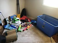 Full lot overview showing assorted water toys and accessories on carpeted floor beside window.