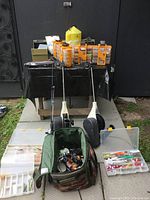 Overview of two fishing rods with reels, tackle boxes, line spool, bait trap and tackle bag