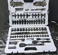 Open case showing organized black chrome sockets, three ratchets, hex keys, and extensions inside a molded plastic case.