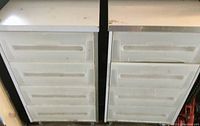 Front view showing two white tool storage shelving units side by side with four hard plastic drawers each.