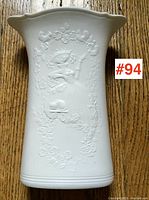 Full view of the white porcelain vase showing the embossed relief decoration