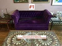 Front view of purple velvet mid-century loveseat showing tufted back, rolled arms, and fabric condition with small marks on seat area.