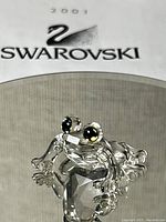 Close-up photo of the 2001 Swarovski mini crystal frog figurine with visible faceted body and detailed eyes.