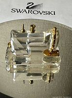 Clear faceted Swarovski crystal miniature sewing machine with gold-tone accents on reflective surface