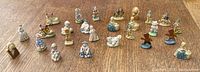 Full lot view showing 26 small Wade Red Rose Tea porcelain figures including children, animals, and cottages.