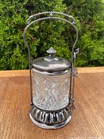 Front view of the pickle cruet with lid closed showing detailed cut glass, hinged handle and base