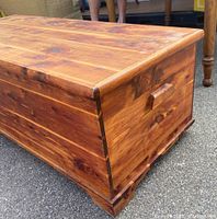 Side view showing rectangular cedar chest with visible wood grain and dovetail joinery at base.