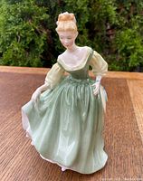 Front view of Royal Doulton Fair Lady figurine showing detailed face and flowing green dress with cream sleeves.