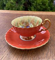 Side-on view of teacup seated on saucer, showing overall shape and color