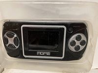 Close-up of a single black Advanced Game Player 2 handheld gaming device with screen, directional pad on left, four buttons on right.