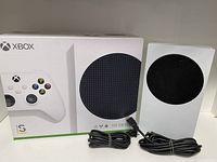Front view of console, retail box and cables