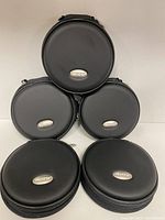 Five black round hard shell GameCube disc cases stacked, showing front and logo.