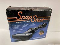 Photo of Redfield Snap Shot hunting scope camera in original box, showing front packaging with product name and graphics.
