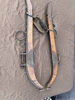 Top-down view of the wooden horse collar showing its full length and metal hardware.