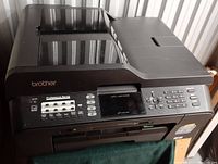 Front and top angled view of Brother MFC-J6510DW showing control panel with buttons and display, front paper trays, and scanner bed on top.