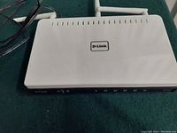 Top and front angled view of the white D-Link DIR-655 router showing the logo, ventilation slits, and connected power cable.