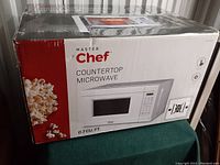 Boxed Master Chef countertop microwave showing front and side with popcorn image and brand logo.