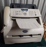 Front view of the Brother IntelliFAX 2820 printer/fax machine showing handset, control panel, and paper tray.