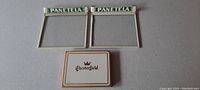 Photo showing two glass cigar box covers with white tin frames labeled 'PANETELA' and one tin cigarette box for Chesterfield.