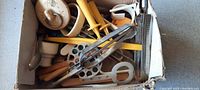 Box of assorted vintage kitchen utensils including graters, corn holders, and slicers from a top view.