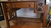 Front view of vintage oak desk showing drawer and decorative side panels