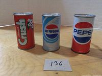 Three vintage soda cans displayed from left to right: Orange Crush, Diet Pepsi-Cola, and Pepsi.