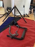 Nikon Coolpix L340, tripod legs and handle bracket on red and blue cloth