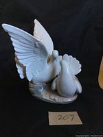Front view of LLADRO dove figurine showing one dove with wings spread and another with fanned tail feathers on a base.