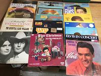 Photo showing front covers of various LP records including several Elvis Presley albums, Kenny Rogers, Tanya Tucker, Patsy Cline, Hank Williams.