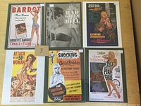 All six movie advertising cards mounted on cardboard in plastic envelopes, showing various colorful and black and white vintage style imagery titled with movie names and taglines.