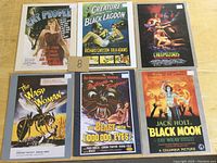 Photo shows six reproduction movie advertising cards each mounted on 11 x 8.25 inch cardboard. Features artwork and titles from classic movies including horror and sci-fi genres.