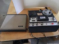 Sony TC-105 reel to reel player with cover set aside, powered by AC cord, showing front face with reels.