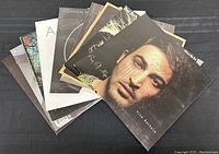 Stack of vinyl records showing prominent album covers including Gino Bacarello