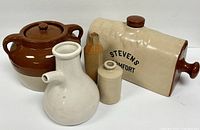 Collection of Stevens Comfort pottery bed warmer flask and four additional pottery vessels on white background