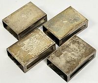 Four rectangular sterling silver matchbox holders with aged tarnishing. Each holder monogrammed with "C.S.B." on the top surface.