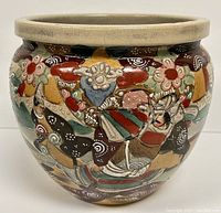 Front view of the antique Satsuma hand painted planter pot showing detailed colorful figure and floral designs.